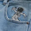 Hellblaue Super-Baggy-Jeans mit Astronauten-Grafik