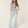 Hoch geschnittene, leicht verwaschene Flare-Jeans mit Rissen