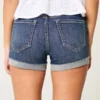 Hoch geschnittene, zerrissene Shorts aus dunkelblauem Denim Hoch geschnittene, zerrissene Shorts aus dunkelblauem Denim