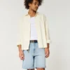 Kniehohe, lockere Jeansshorts im Used-Look