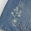 Ultra Low-Rise Mini-Shorts aus mittelblauem Denim mit Blumenstickerei